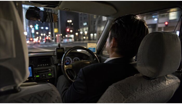 夜間勤務で疲労を感じているタクシードライバーの後ろ姿