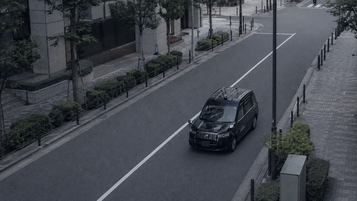 通りを走るジャパンタクシーを見下ろした俯瞰の風景