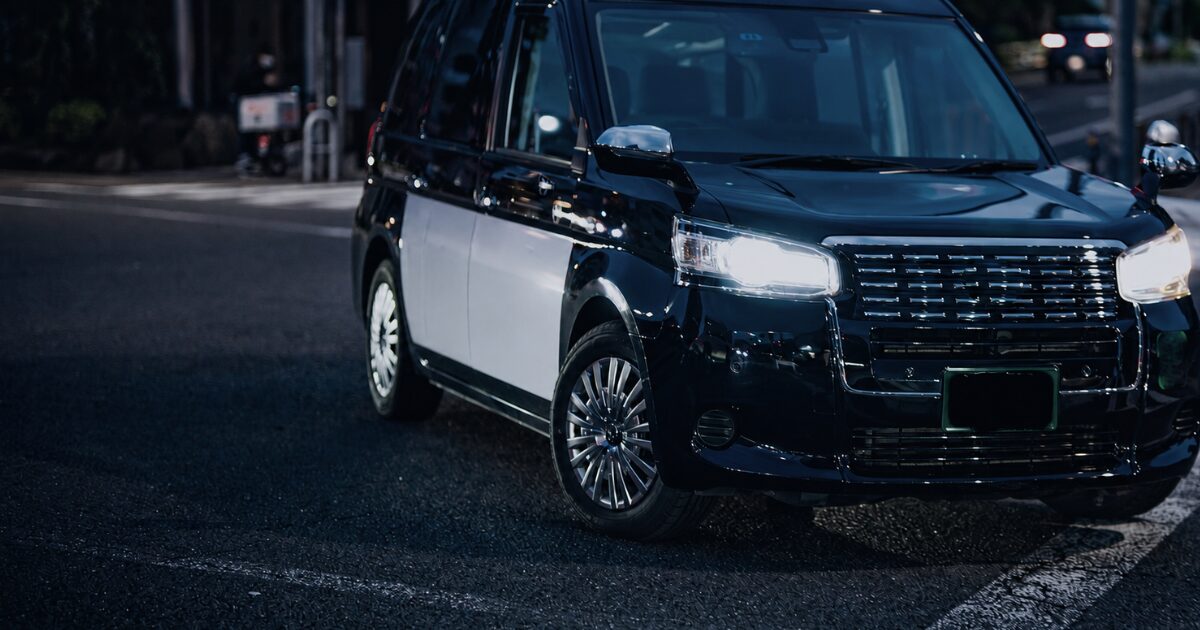 夕暮れの交差点に停まるタクシー