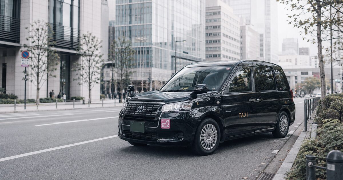 ビル街の道路に停まる昼間のジャパンタクシー